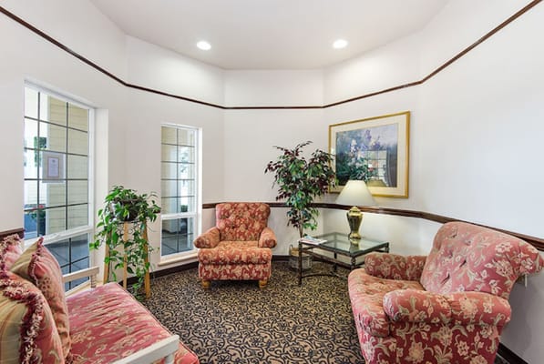 Cozy common area with floral furniture and a lamp
