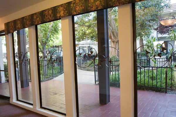 Large windows with decorative ironwork overlooking a garden area.