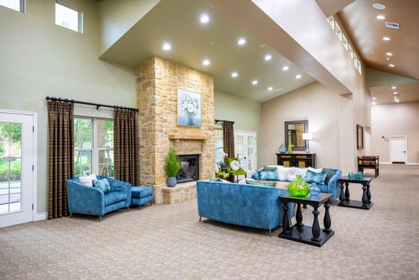 A spacious common area with comfortable seating and a fireplace