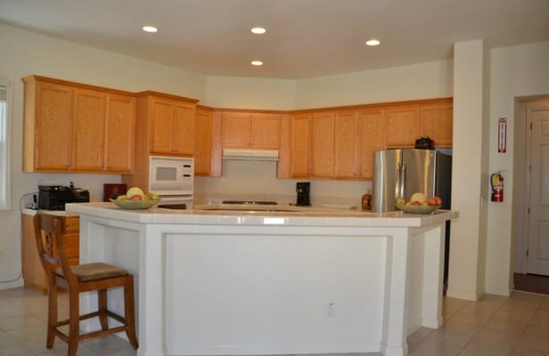 Spacious kitchen with wooden cabinets and countertop fruit bowl