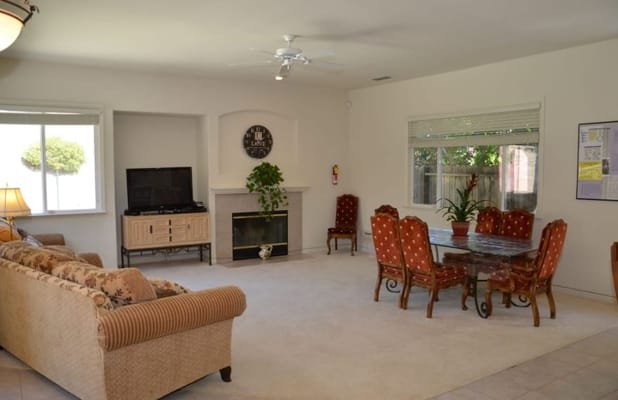 Bright living and dining area with a couch, TV, and dining table