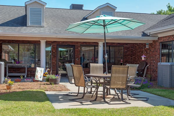 Outdoor seating area with chairs and a table under an umbrella