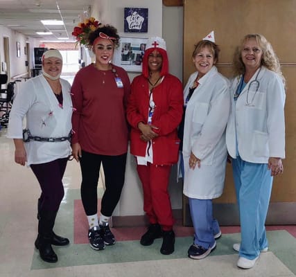 Group of five staff members in a healthcare facility hallway