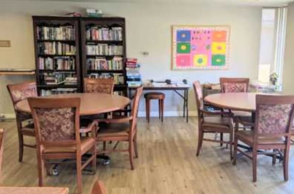 Interior view of a common area with tables and a bookshelf