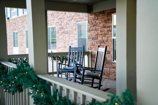 Rocking chairs on a porch decorated for the holidays
