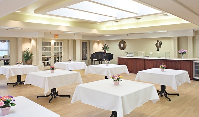 Light and airy dining area with tables set up and flowers