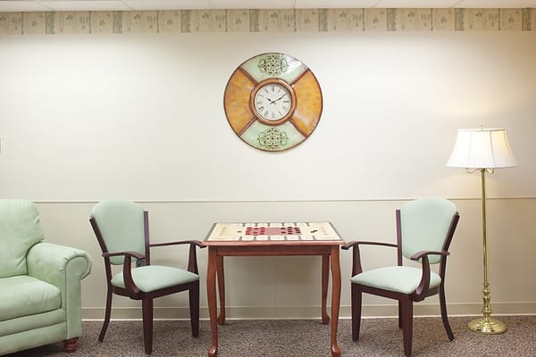 Lounge area with a green couch, table, and chairs
