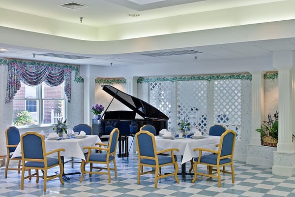 Dining room with tables, chairs, and a piano.