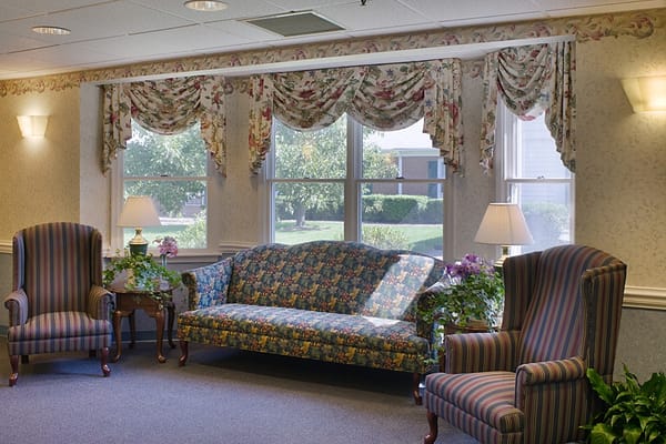 Cozy seating area with floral couch and striped chairs by the window