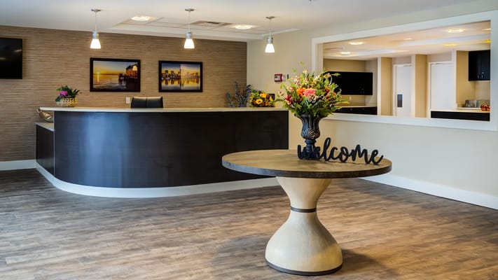 Reception area with a welcome sign and floral arrangement