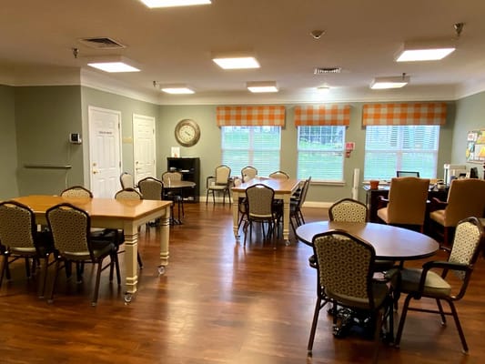 Interior view of a common area with tables and chairs.