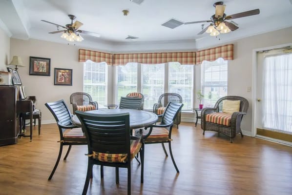 A bright and inviting common area with dining tables and chairs.