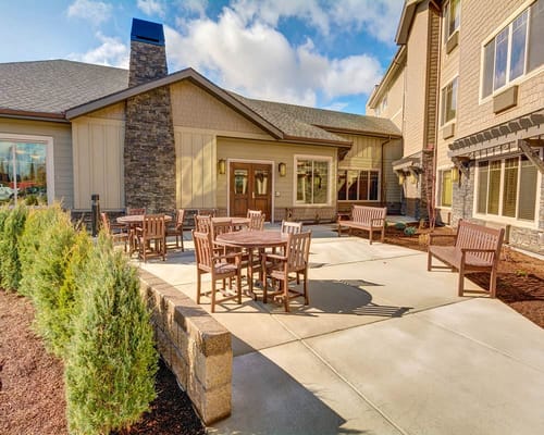 Outdoor seating area with tables and chairs at Mt. Bachelor Memory Care
