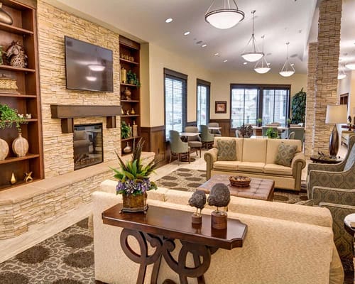 Cozy living room with decorative stone fireplace and seating area.