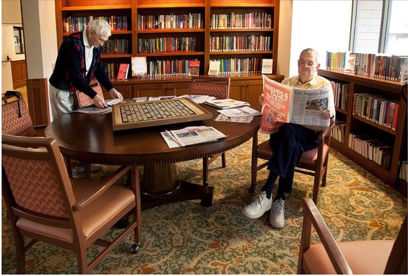 Residents enjoying activities in a cozy library space