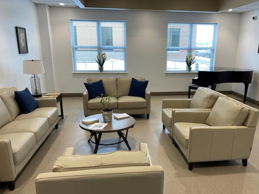 Bright common area with seating and a piano