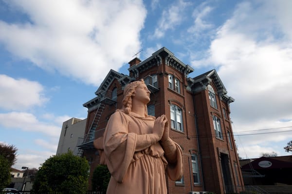 Exterior view of a historic building with statue