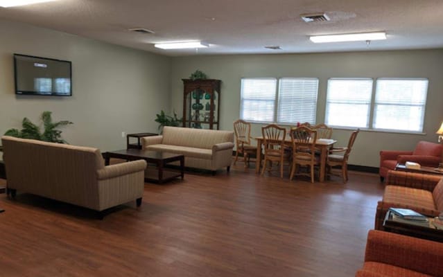 Common area with sofas and dining table in a senior living facility