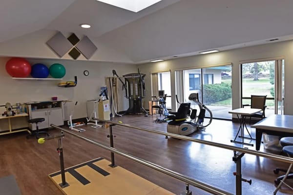 Interior view of therapy room with exercise equipment and large windows