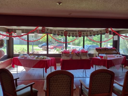 Decorated event space with red tablecloths and a 'Thank You Nurses' banner.