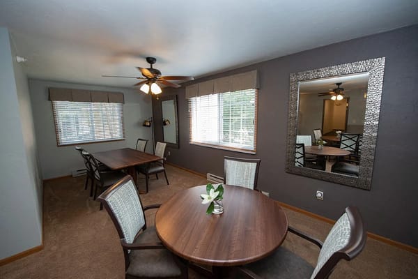 Dining room with wooden tables and chairs at Ridgeview Highlands Apartments.