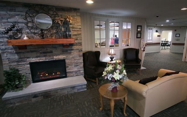 A comfortable living room with a stone fireplace and seating area.