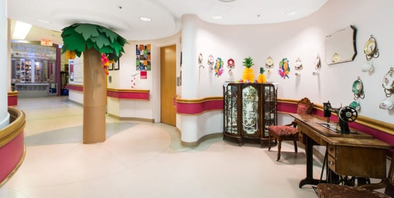 Brightly decorated lobby with a tree and art displays