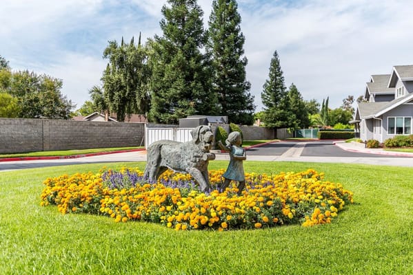 Sculpture of a child with a dog surrounded by flowers