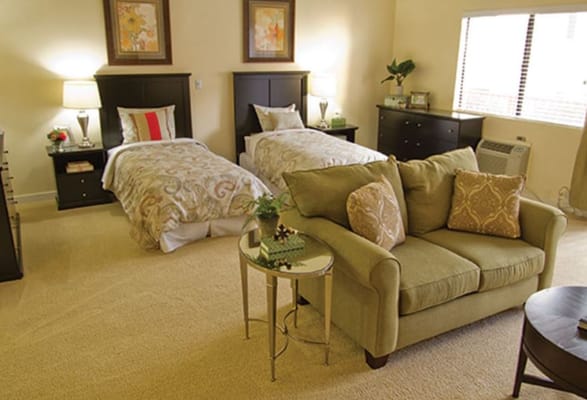 Bright and inviting shared bedroom with two beds and a seating area.