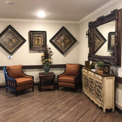 Two comfortable chairs with decorative wall art and a side table