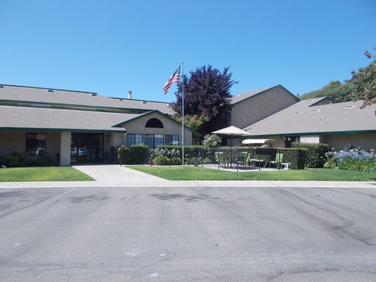 Front view of Sutter Estates with American flag and landscaped area
