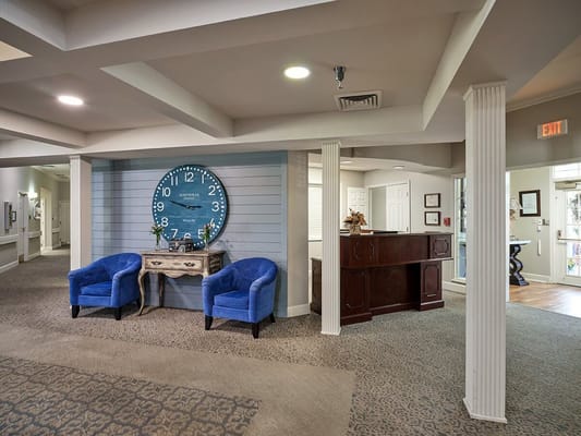 View of the lobby with blue chairs and a large clock