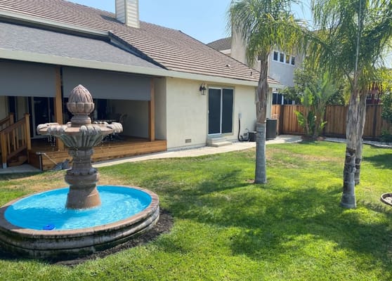 Outdoor fountain with blue water feature in a garden.