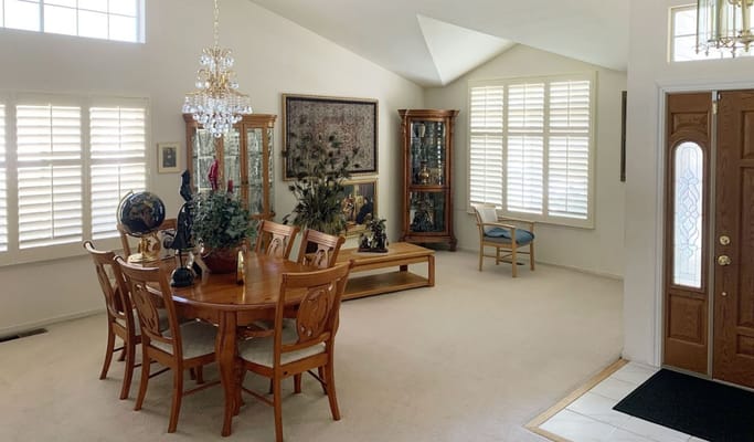 Spacious dining area with wooden furniture and decorative elements.
