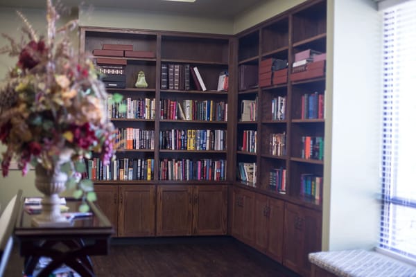 Bookshelves filled with various books in a cozy corner