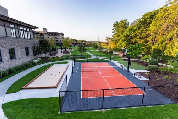 Outdoor basketball court and bocce ball court with landscaped gardens.