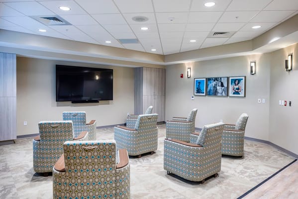 Cozy lounge area with patterned chairs and a large TV