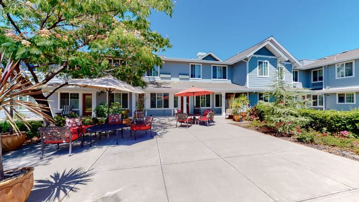 Outdoor seating area with umbrellas and plants at The Commons at Dallas Ranch