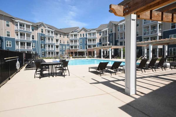 Outdoor pool area with seating and sun loungers