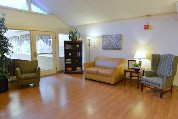 Cozy living room with seating, bookshelf, and lamp