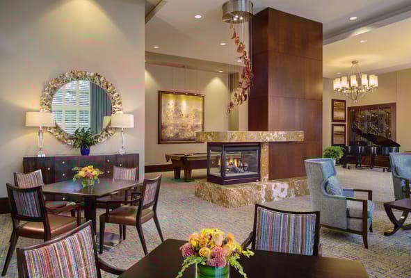 Lounge area with a fireplace, seating, and flowers at The Mather.