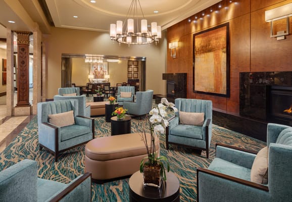 Spacious living room with teal chairs and decorative plants