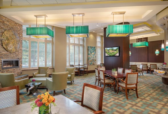 Brightly lit community lounge with seating and decorative elements