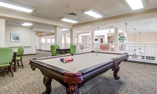 Bright activity room with a billiard table and seating