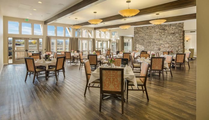 Elegant dining area with tables set for meals and large windows