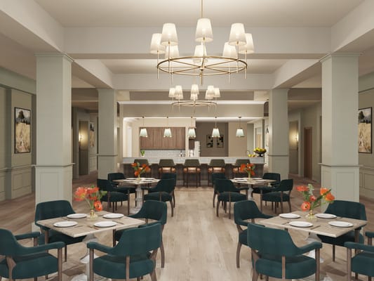 Elegant dining room with tables and chairs, featuring floral centerpieces.