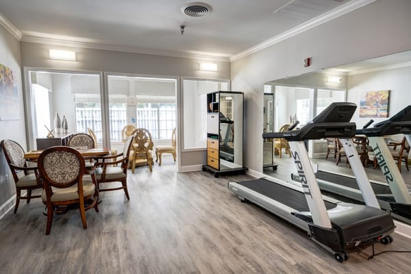 Bright fitness area with treadmill and dining space