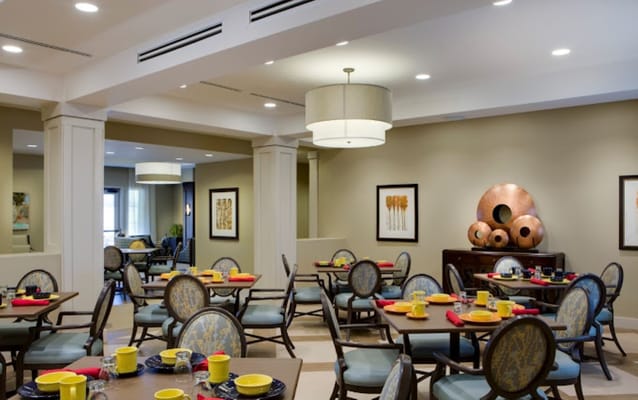 Bright and inviting dining room with tables set for residents