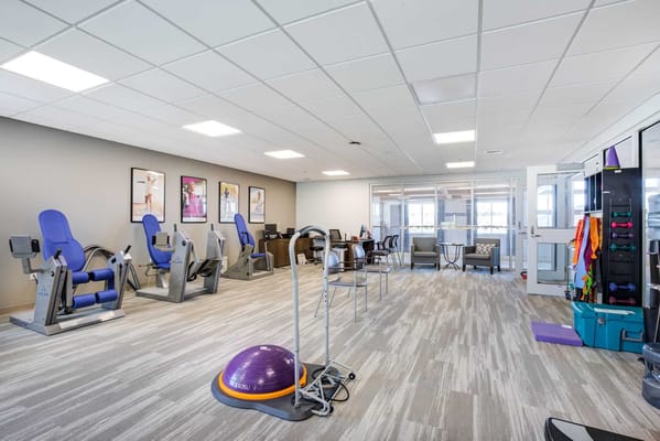 A spacious fitness area with exercise equipment and seating