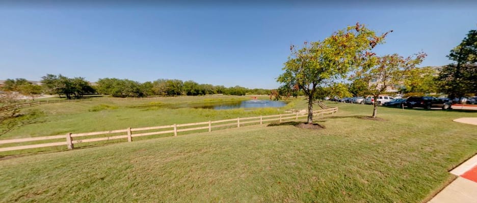 View of a serene pond surrounded by greenery and trees